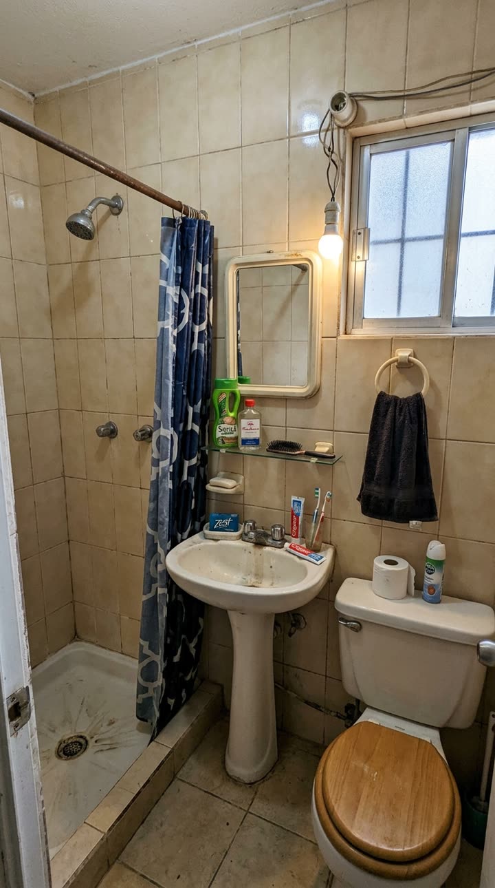 Foto real de un baño viejo, tomada con el celular